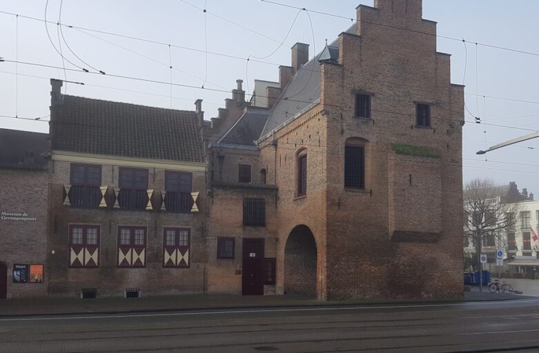 a train traveling past a tall brick building
