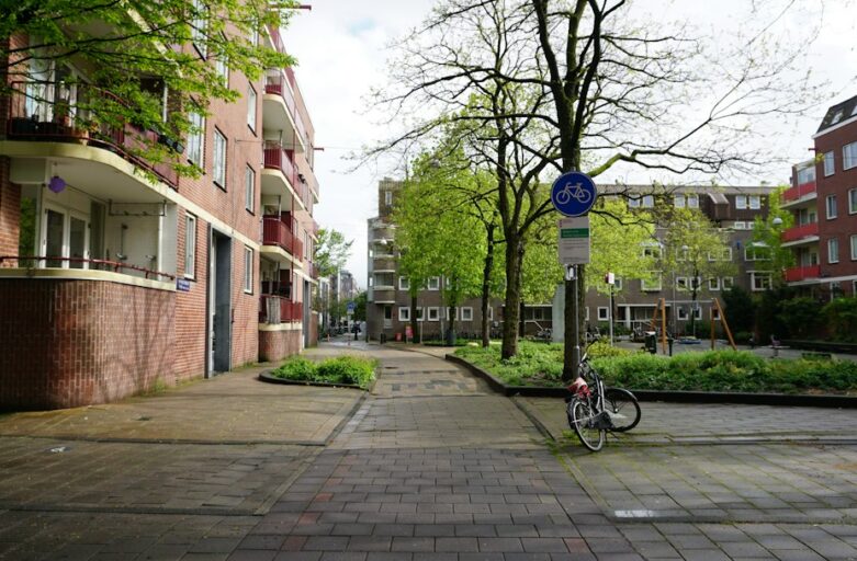 a bike parked on the side of a road next to a street sign